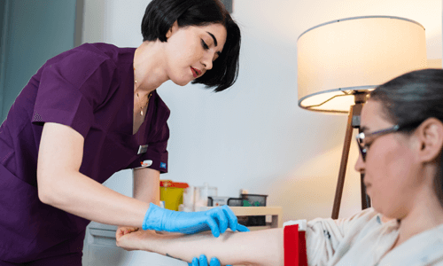 Female health care professional preparing to administer a blood test on female patient