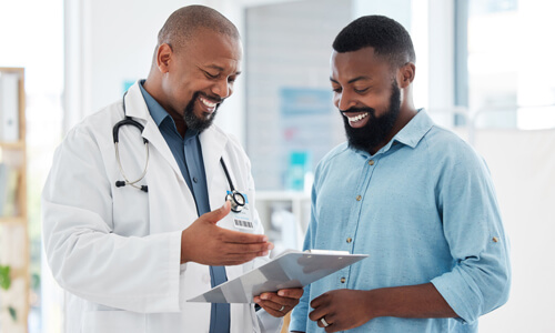 Male health care professional sharing information with male patient