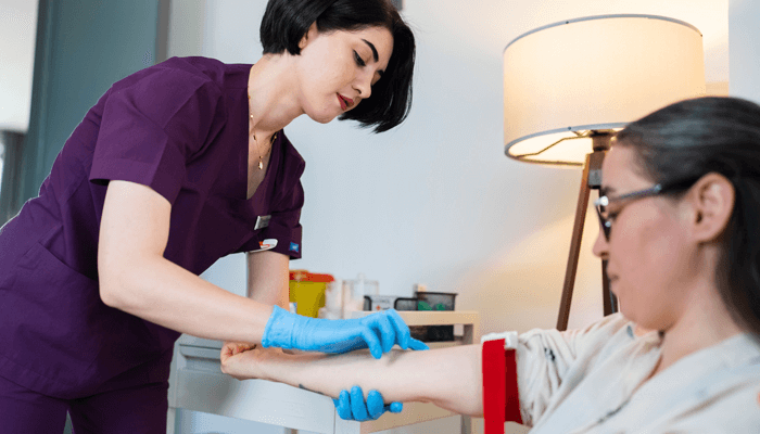 Female health care professional preparing a female patient's arm for testing